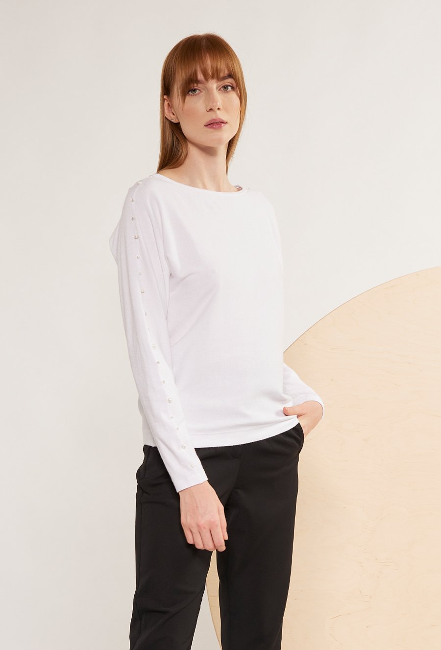 Biały sweter ze zdobieniem na rękawach